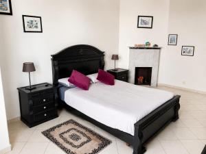 a bedroom with a bed with purple pillows and a fireplace at Cosy Art Deco Apart Welcome to James's in Casablanca