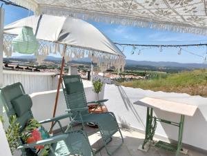 a couple of chairs and an umbrella on a patio at Casa da Muralha in Estremoz