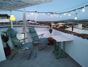 a patio with chairs and a table on a roof at Casa da Muralha in Estremoz
