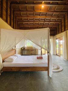 ein Bett mit Himmelbett in einem Zimmer in der Unterkunft Mahati in Cijulang Nusawiru Airport