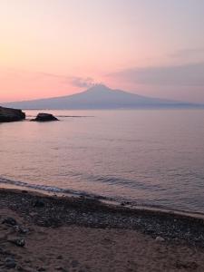 a sunset over the ocean with a mountain in the background at Ursino inn camere e suite in Catania