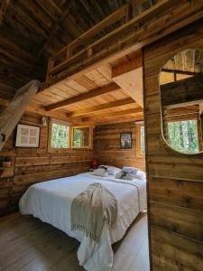 a bedroom with a bed in a wooden cabin at Le Chalet Lasseube in Lasseube