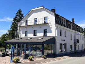 a white building with a balcony on top of it at Beau-sejour in Francorchamps