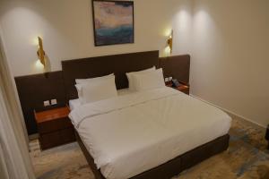 a bedroom with a large bed with white sheets and pillows at Sambac hotel in Jeddah +42 photos
