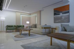 a living room with couches and a table and chairs at Sambac hotel in Jeddah