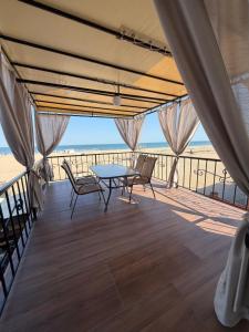 a balcony with a table and chairs on the beach at Hotel Olimp in Zatoka