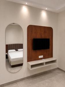 a bedroom with a mirror and a bed and a tv at Hotel Abhishek Pride Shani Shinganapur in Godhegaon