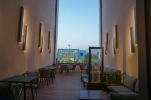 a restaurant with tables and chairs and a large window at Sambac hotel in Jeddah