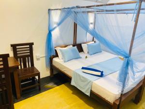 a bedroom with a bed with a blue canopy at Aaliya Bay in Pottuvil +73 photos