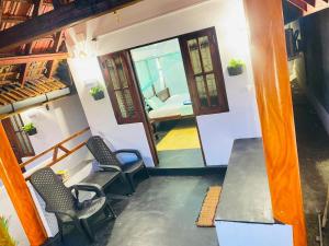 a room with chairs and a table and a bedroom at Aaliya Bay in Pottuvil