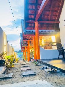 a balcony of a building with a bench and shoes at Aaliya Bay in Pottuvil