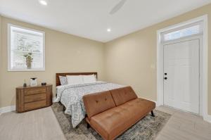 a bedroom with a bed and a brown leather couch at Korovosoto Lodge in Dallas