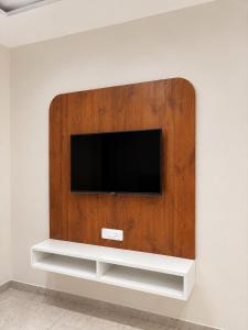 a flat screen tv mounted on a wall at Hotel Abhishek Pride Shani Shinganapur in Godhegaon