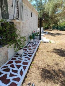 a house with a stone path in front of a house at Helios Beach House in Mikros Gialos
