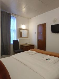 a room with a bed and a chair and a window at The Jack Sparrow Hotel in Blackpool