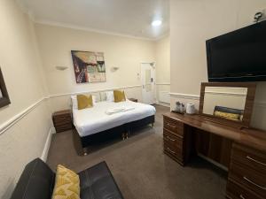 a hotel room with a bed and a flat screen tv at The President Hotel in Blackpool