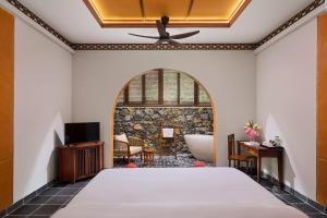 a bedroom with a bed and a bathroom with a tub at Hang Múa Ecolodge Ninh Hoà in Ninh Binh