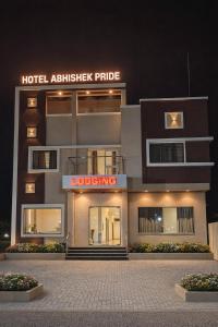 a hotel apartment building with a hoteladobeadobe price sign on it at Hotel Abhishek Pride Shani Shinganapur in Godhegaon