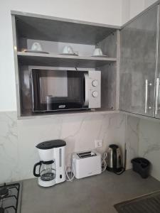 a kitchen with a microwave and a coffee maker at Keur Moussa in Dakar
