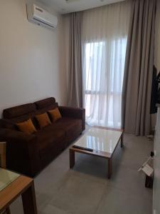 a living room with a brown couch and a coffee table at Keur Moussa in Dakar