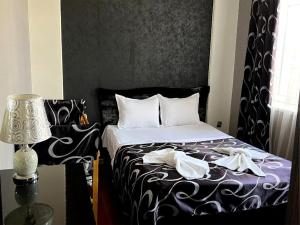 a bedroom with a bed with white sheets and a lamp at Imperia in Akhaltsikhe
