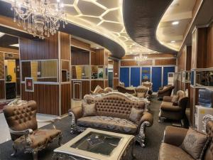 a living room filled with furniture and a chandelier at Qorqud Hotel - Free Massage in Baku