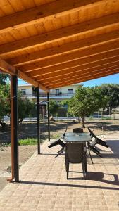 a patio with a table and chairs under a wooden roof at Todos home in Amalias