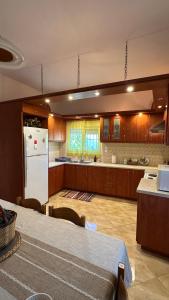 a kitchen with a table and a white refrigerator at Todos home in Amalias +11 photos