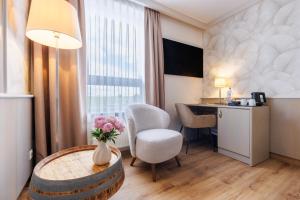 a hotel room with a table and a desk at Weinberghotel Edelacker in Freyburg