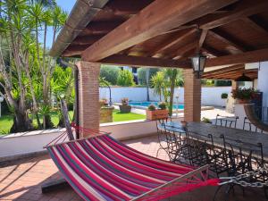 a hammock sitting on a patio with a table and a tableablish at La casetta di Daniela in Sabaudia