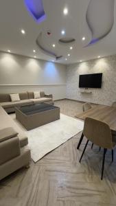 a living room with a couch and a flat screen tv at منتجع وفلل المرفأ ابها in Abha