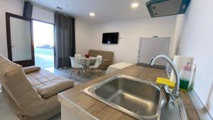 a kitchen with a sink and a living room at 1 linea de playa - Apartamentos - Beach & River - Conil in Conil de la Frontera +53 photos