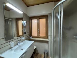 a bathroom with a sink and a shower at Hotel Garnì Ai Serrai in Rocca Pietore +30 photos
