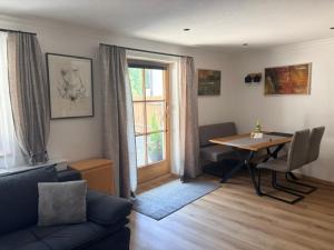 a living room with a couch and a table and a window at Gasthof Perfler in Außervillgraten