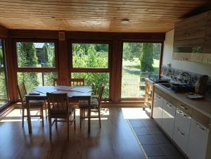 a kitchen and dining room with a table and chairs at Zacisze in Kołczewo +43 photos