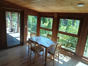 a wooden table and chairs in a room with windows at Zacisze in Kołczewo
