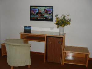 Elle comprend un bureau avec un ordinateur et une télévision murale. dans l'établissement Hotel Barberino, à Barberino di Mugello