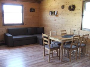 a living room with a table and chairs and a couch at Domki Lawendowa Skarpa in Zawóz