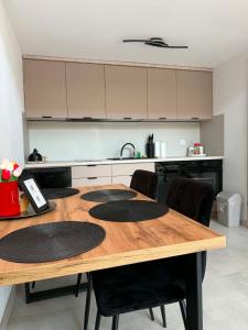 a kitchen with a wooden table and black chairs at Stodoła Nad Dunajcem in Sromowce Wyżne
