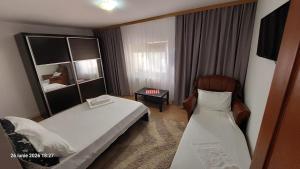 a hotel room with a bed and a chair at Casa Vio parter in Eforie Nord
