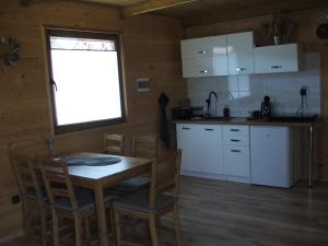 a kitchen with a table and chairs in a room at Domki Lawendowa Skarpa in Zawóz +13 photos
