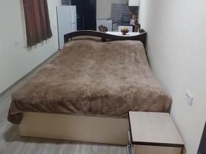 a large bed in a room with a table at Meghri Hotel in Meghri