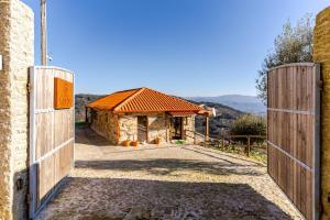 an entrance to a building with a wooden gate at Casa do Sol com Piscina and Sauna para 6 Pessoas in Celorico de Basto