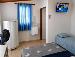 a small room with a refrigerator and a sink at Apartamentos-6-3-8 - Pousada Itapetininga in Itapetininga