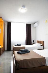 a hotel room with three beds and a window at Nuvelle Boutique Hotel in Prizren