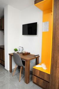 a kitchen with a wooden table with a chair and a tv at Nuvelle Boutique Hotel in Prizren