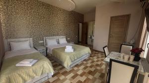 a hotel room with two beds and a mirror at Hotel New Royal in Tbilisi City