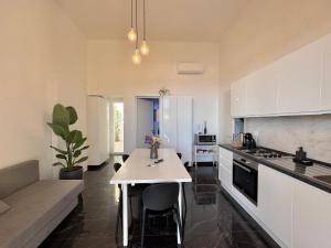 a kitchen with a table and a couch in a room at Villa Nauna - Beachfront Villa with Garden & Sea-View Terrace Santa Caterina - Marea Stays Collection in Nardò