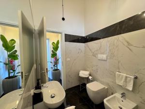 a bathroom with a white sink and a toilet at Villa Nauna - Beachfront Villa with Garden & Sea-View Terrace Santa Caterina - Marea Stays Collection in Nardò +45 photos