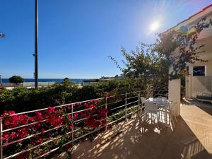 a balcony with a table and chairs and flowers at Villa Nauna - Beachfront Villa with Garden & Sea-View Terrace Santa Caterina - Marea Stays Collection in Nardò